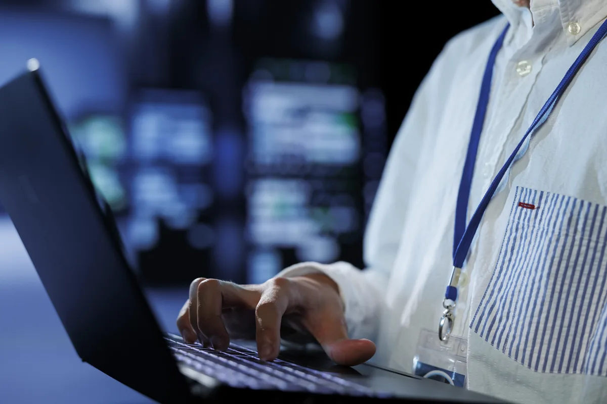 Técnico utilizando una laptop para trabajar en la infraestructura tecnológica